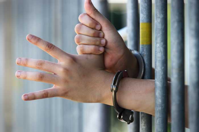 hands in handcuffs in jail at juvenile detention center