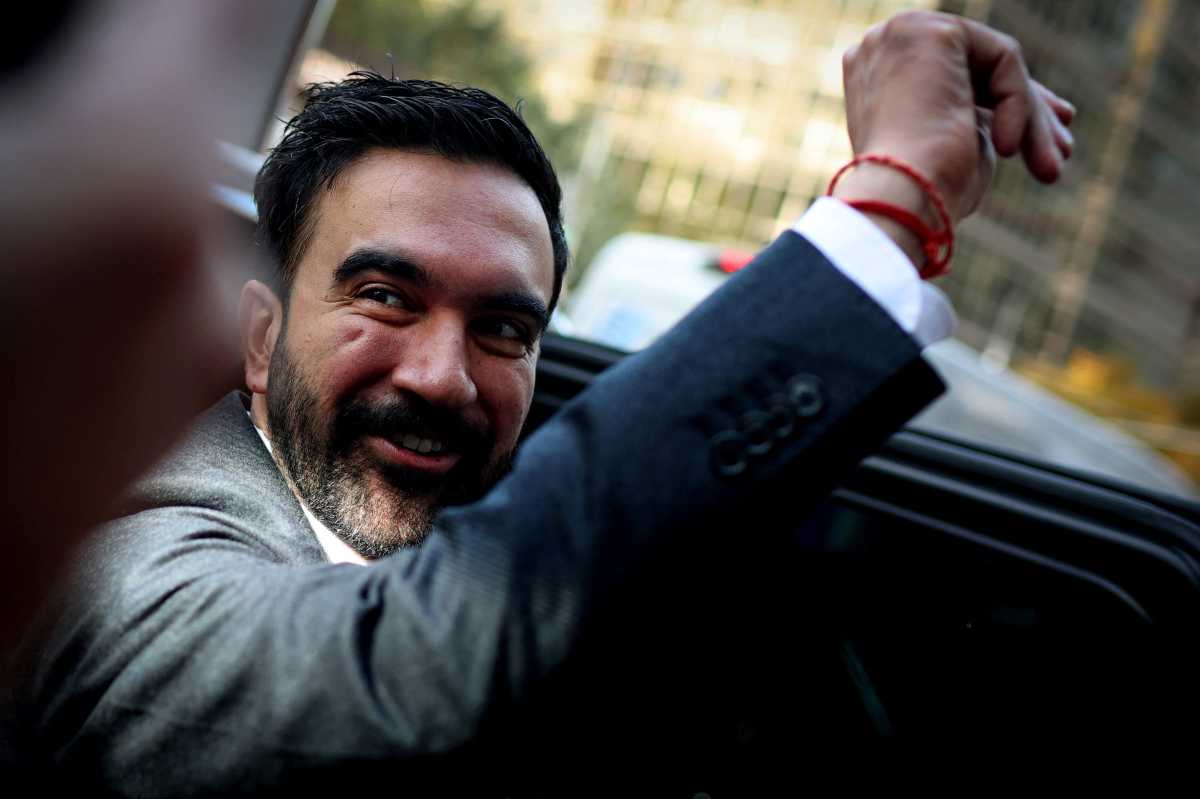 NYC Mayoral candidate Zohran Mamdani smiling and raising fist