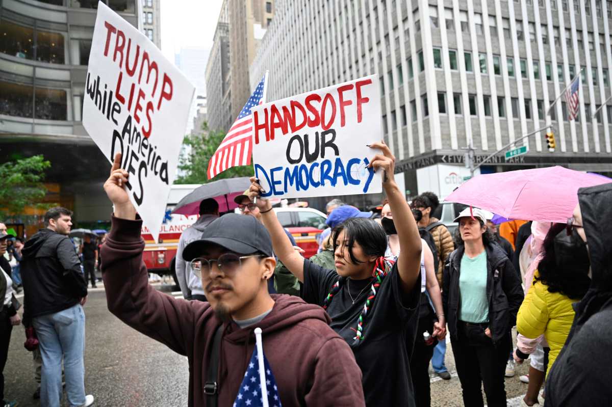people holding up signs at No Kings Day rally