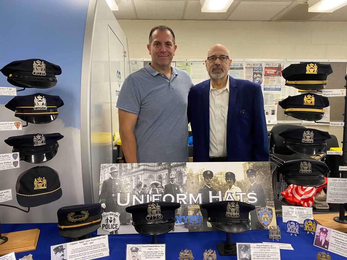 two men standing at a table of police hats