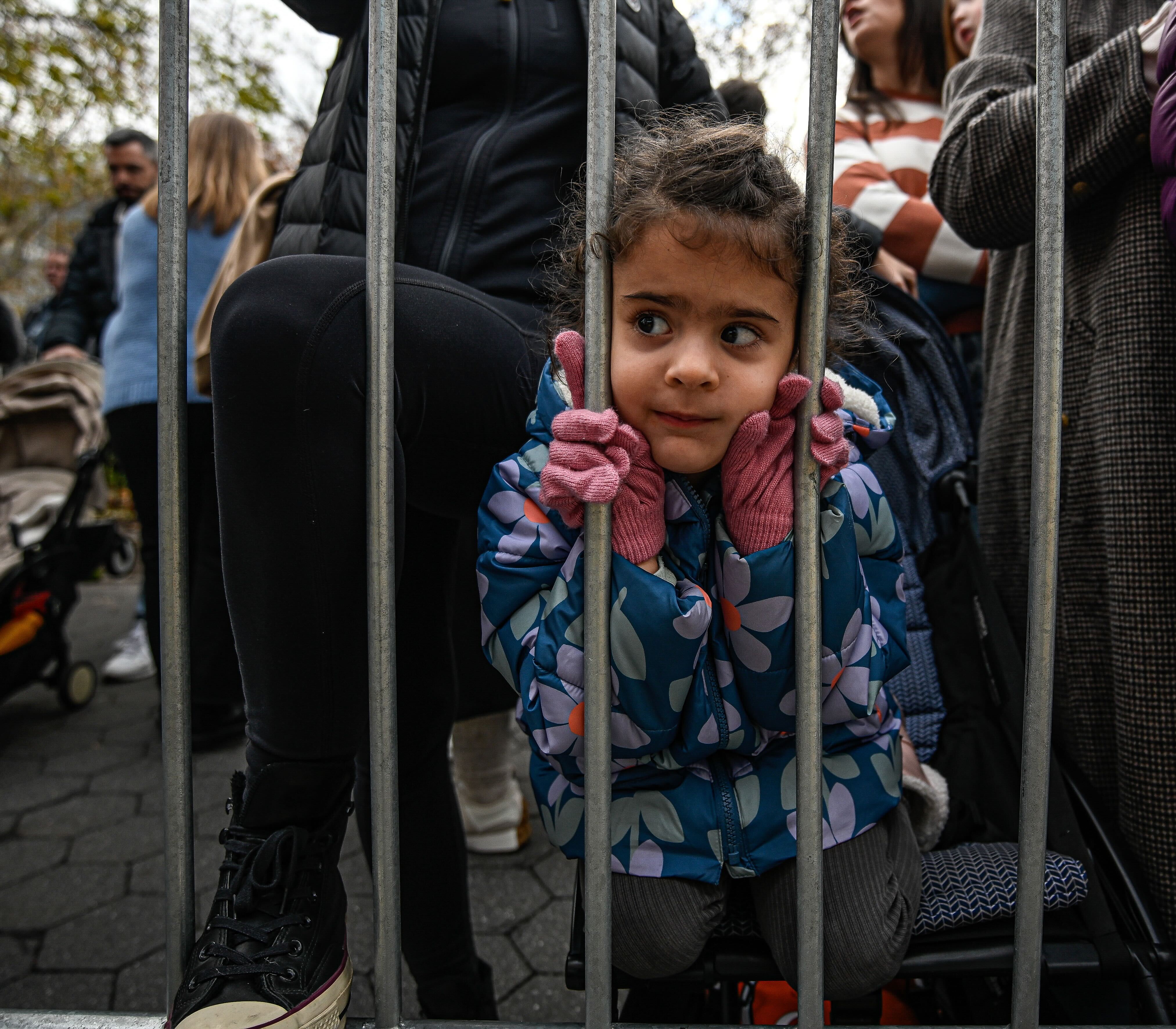 a young girl leans on a barricade