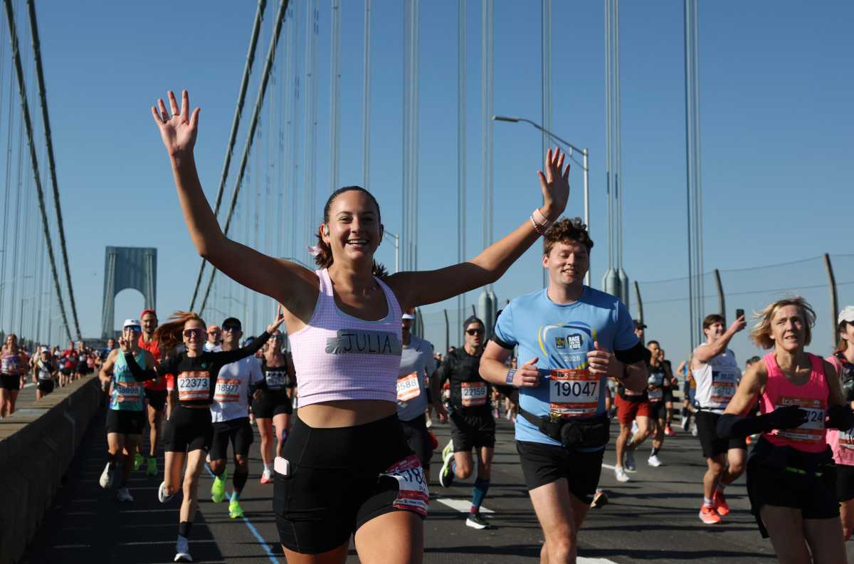 NYC MARATHON: Perfect weather and energized New Yorkers greet 55,000 runners for the great five-borough race 2 NYC Marathon runner raises arms while crossing the Verrazzano Narrows Bridge