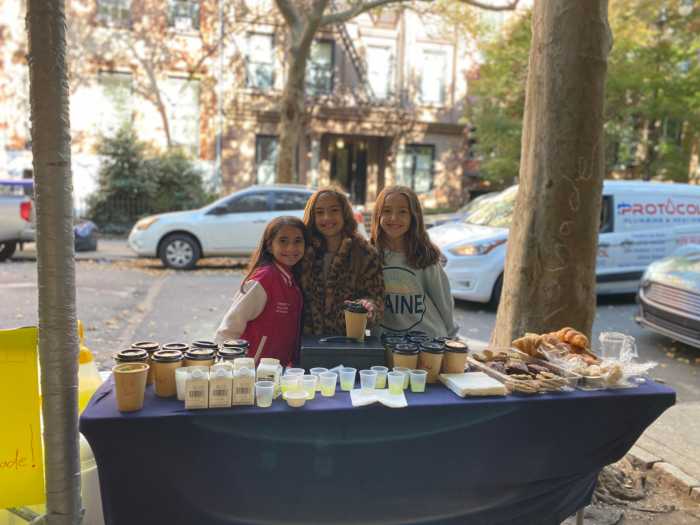 From left, Penelope, Hayley and Annika sell baked goods and lemonade outside PS41, raising funds for their class while helping direct voters to the correct entrances at the busy polling site.