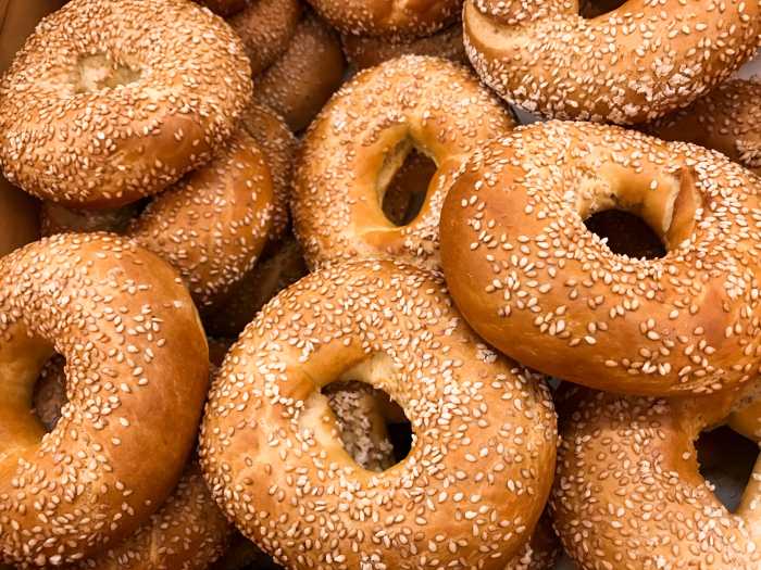 Close-up of a pile of freshly baked bagels sprinkled with sesame seeds