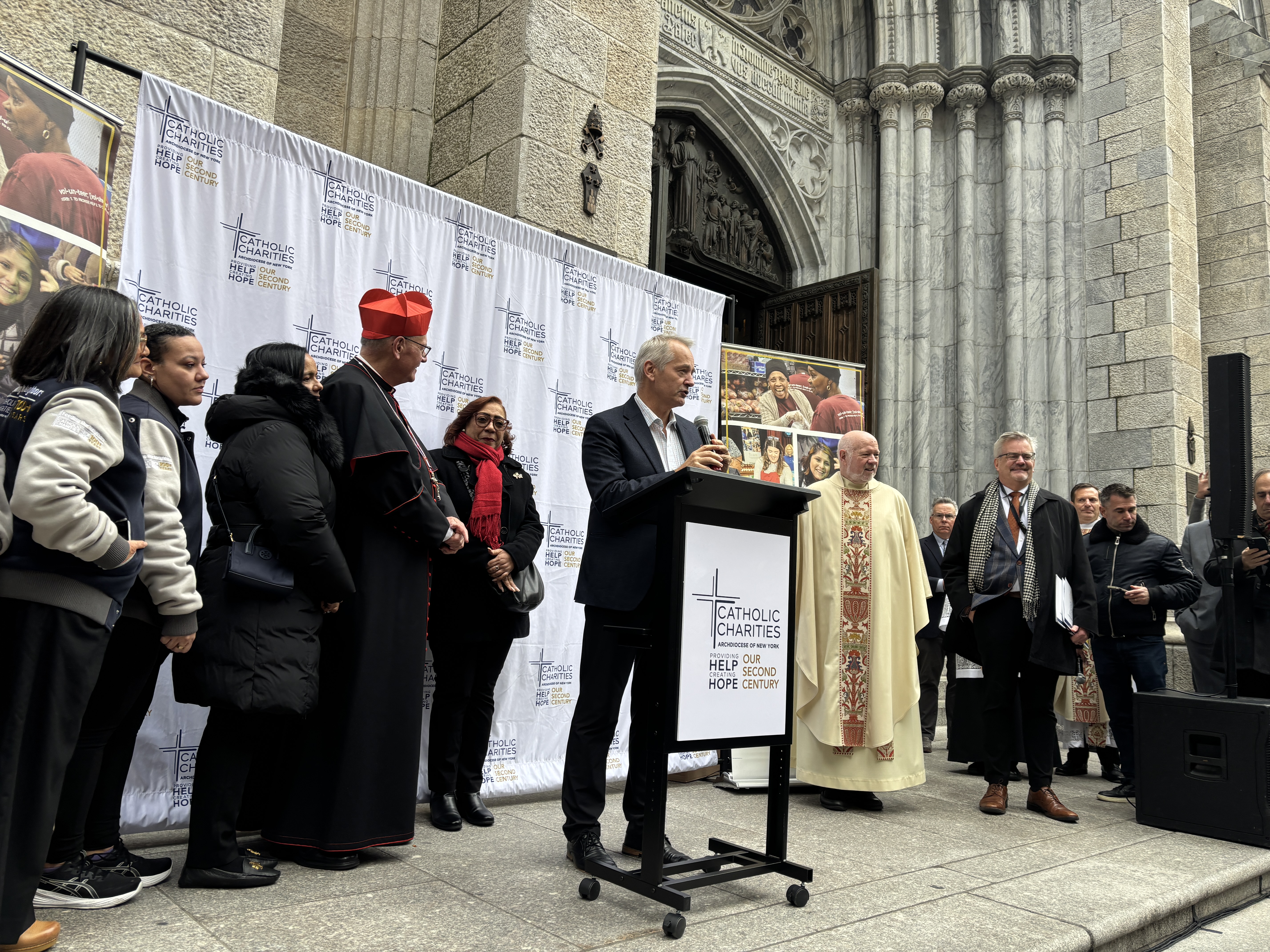 Reps from Catholic Charities address the crowd.