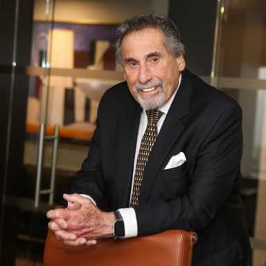 man standing behind a chair wearing a suit Sid Davidoff