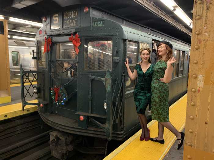 Season’s greetings on the subways! Nostalgia Rides on NYC vintage trains return this holiday season 2 two women dressed in green dresses on a subway platform
