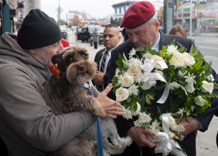 NYC Mayor's Race: One more ride for the red beret, as Curtis Sliwa campaigns to the very end 2 two men, one holding a wreath and one holding a dog