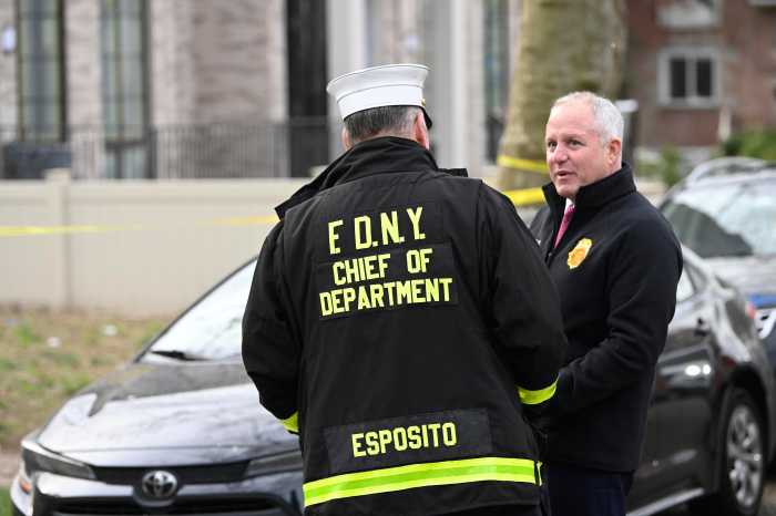two men wearing black, one in a fire department uniform
