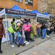 Giving thanks, and giving back: Governor Hochul, Cardinal Dolan host Thanksgiving food distribution in Harlem 9 people on line at a food distribution event