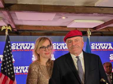 man wearing a red beret and a woman wearing gold dress