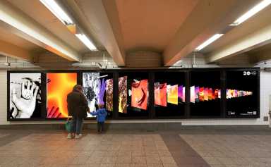 woman and child looking at photos in a NYC train station