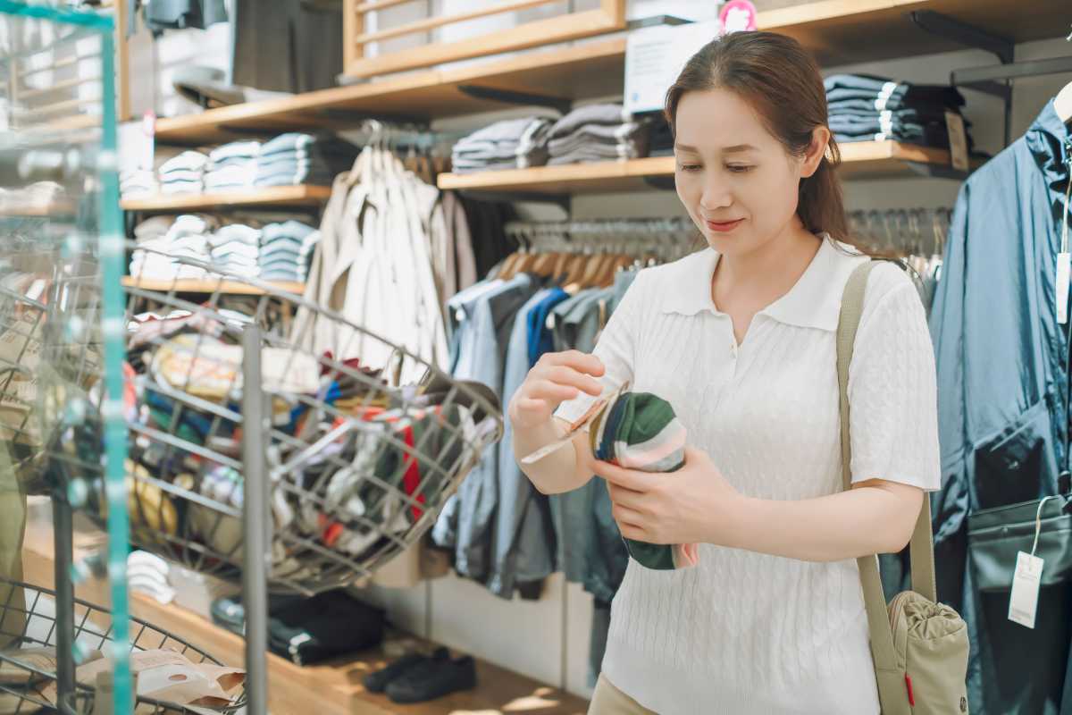 A Woman Examining a Product in a Clothing Store small businesses