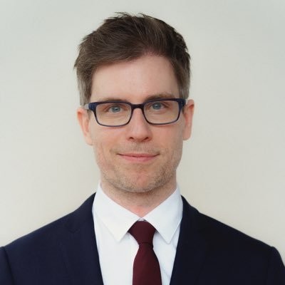 man wearing glasses and a suit