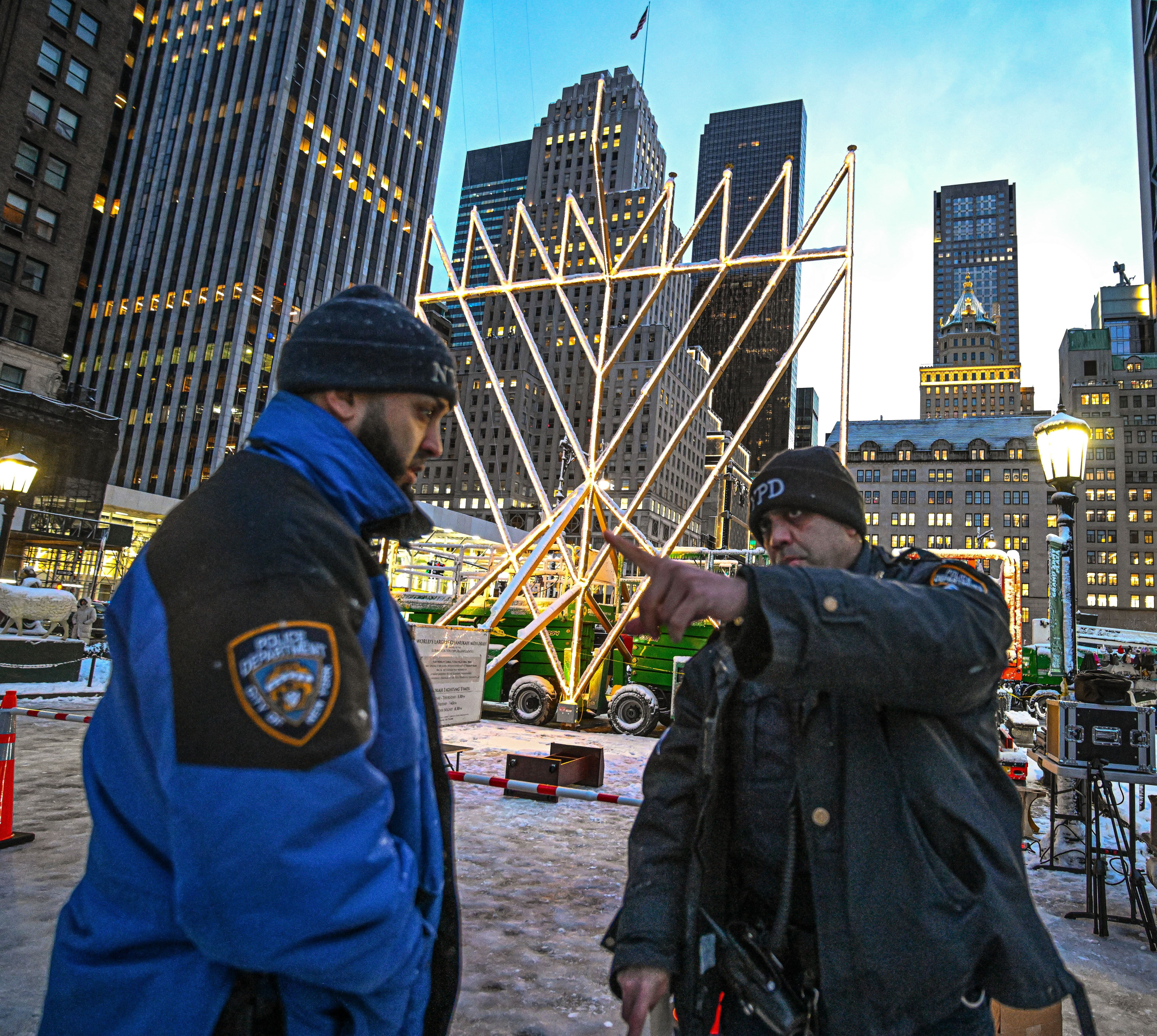 police officer in uniform standing in front of a large menorah
