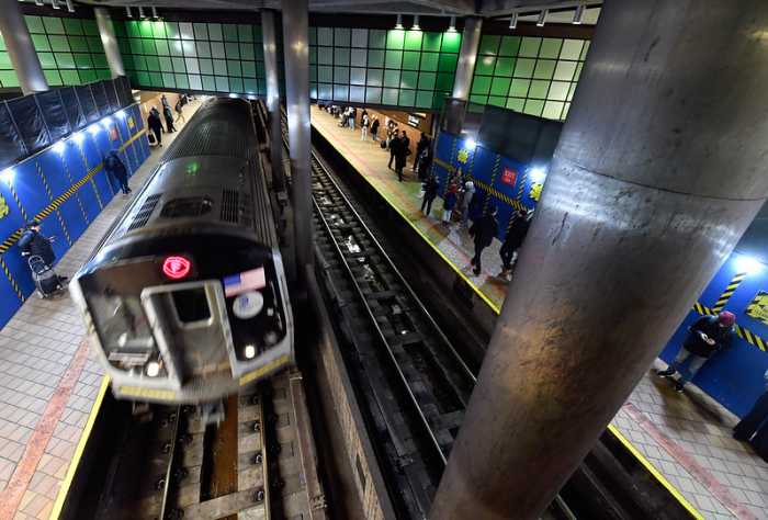 F train running through Queens subway station