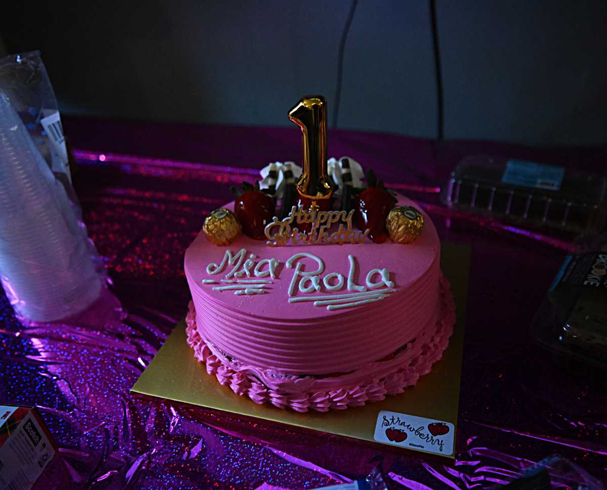 pink birthday cake with a candle for a girl whose father was detained by ICE 