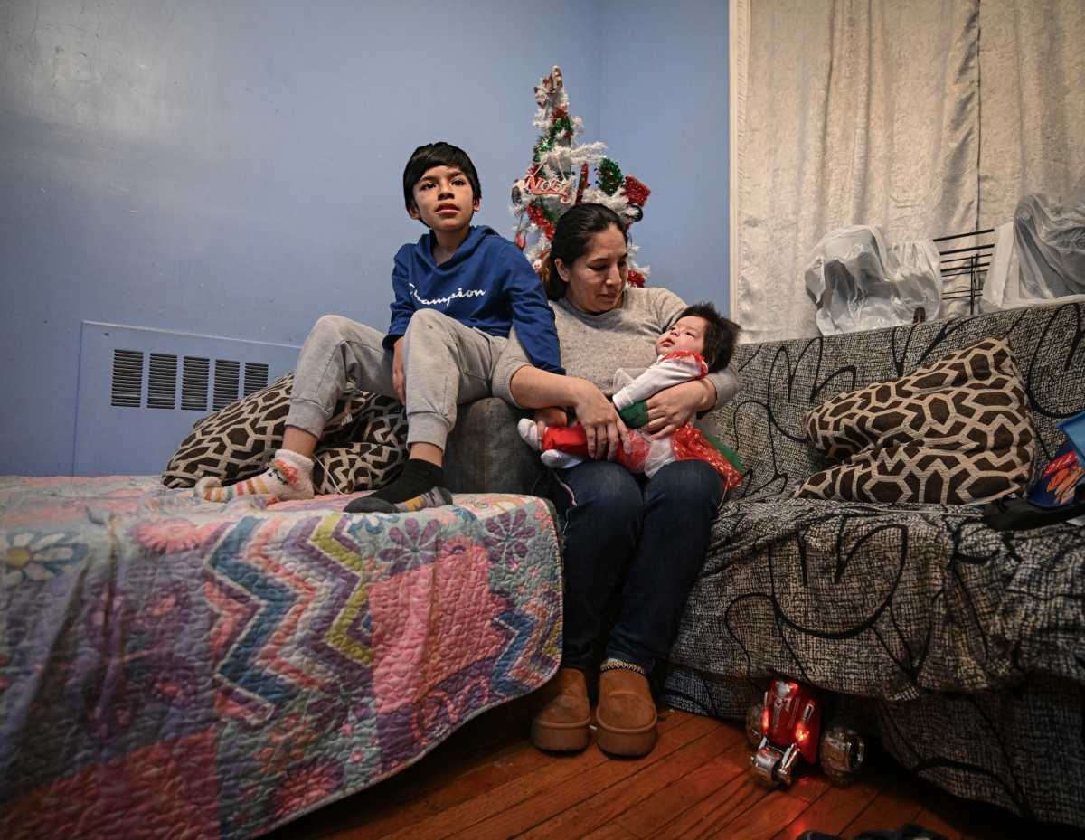 Mom and children of man deported by ICE sit on bed during Christmas