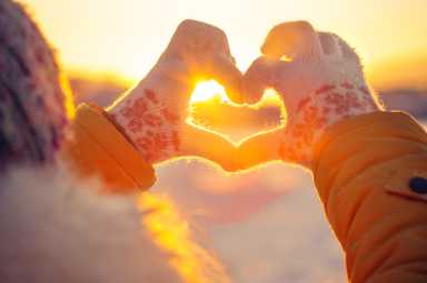 Woman hands in winter gloves Heart symbol