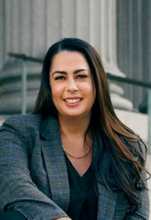 Judge Allison Greenfield, who ruled LLCs are exempt from a more relaxed service statute that corporations are eligible for, sits smiling in front of a courthouse.