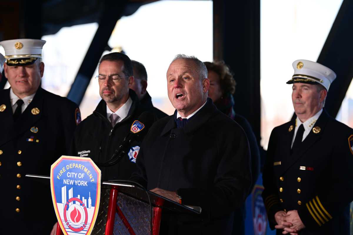 group of men, several in dress FDNY uniforms at a podium