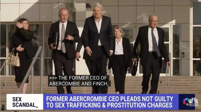 Ex-Abercrombie CEO Michael Jeffries walks out of the Central Islip federal courthouse wearing a suit with other suited men on either side of him.