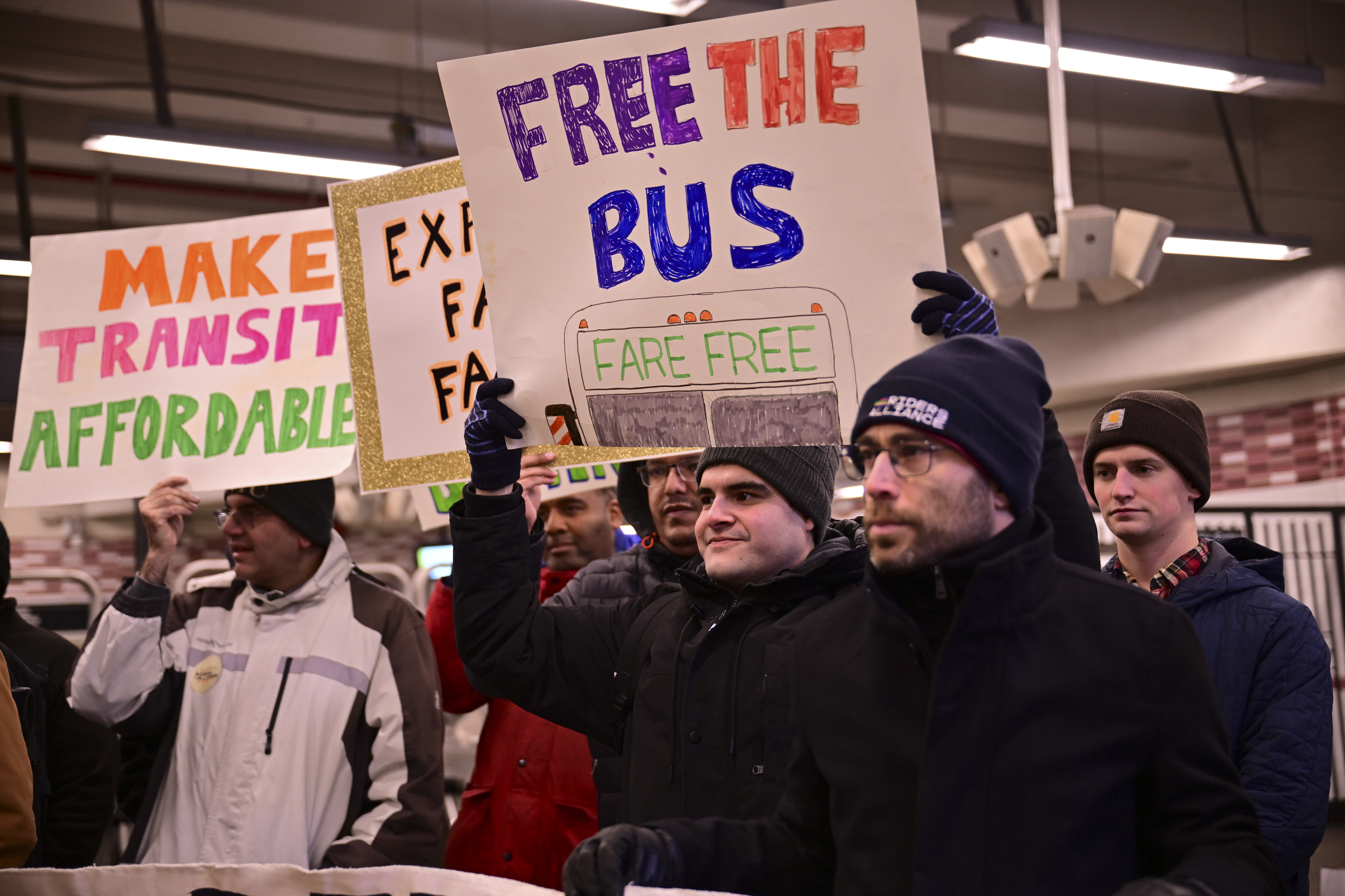 group of people in winter coats holding signs