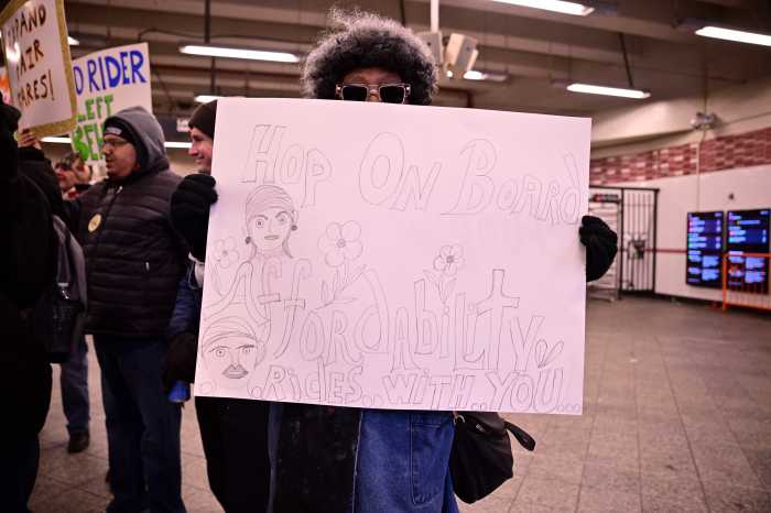 'Make the buses free!' Transit advocates rally in Brooklyn demanding that Mamdani make good on his key transit promise 3 people wearing winter coats and holding signs inside a subway station