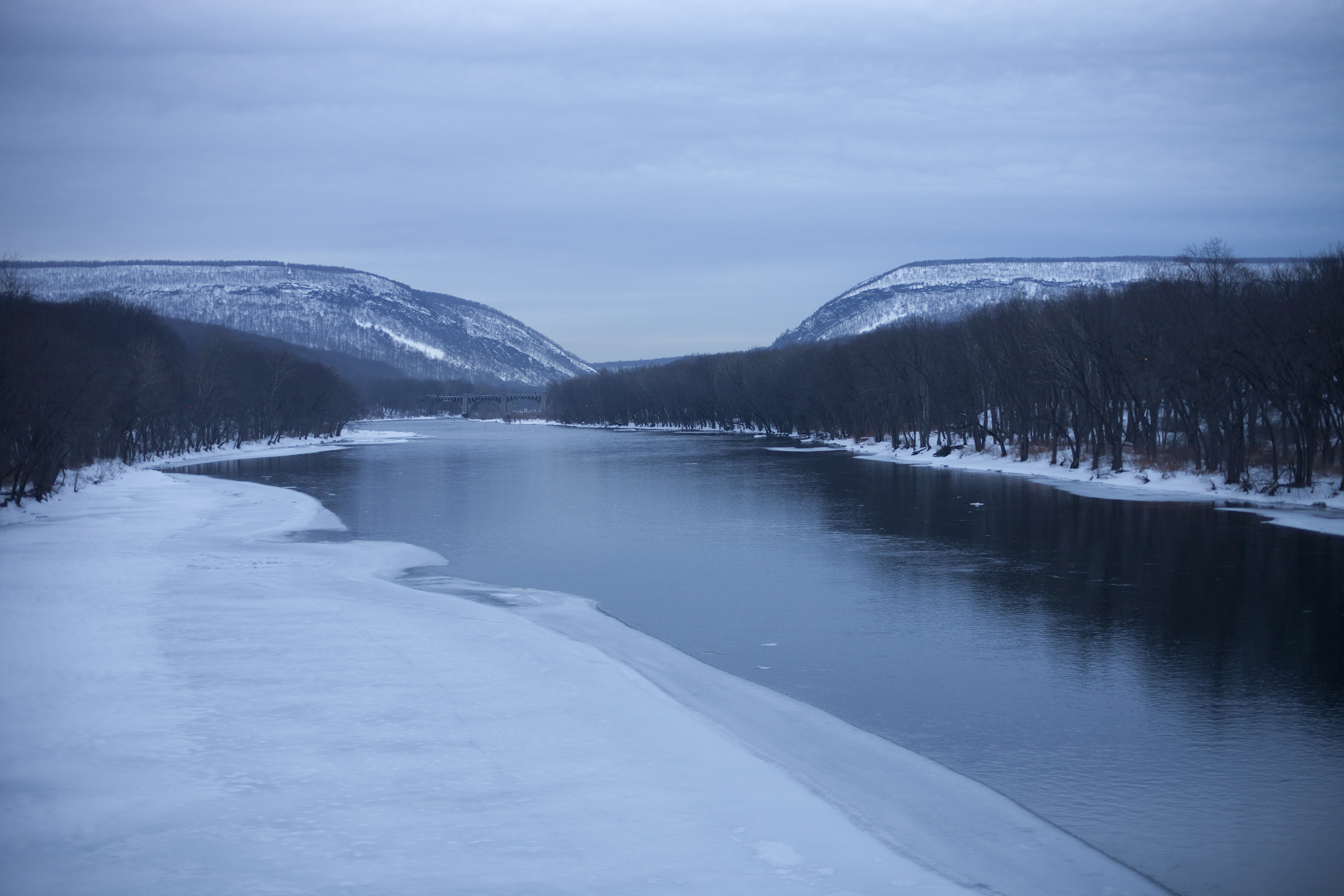 Things to do this winter in the Poconos 4 Frozen water at the Delaware River with the mountains of the Delaware Water Gap in the background, ice banks and trees on the river edge. Part of the Delaware Water Gap National Recreational Area in Pennsylvania.