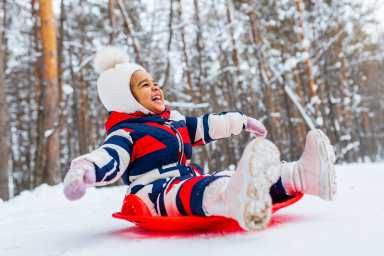 child happily enjoying a sleigh ride