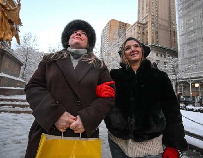 Hanukkah celebrations continue in NYC despite antisemitic terrorist attack in Australia 3 two women bundled up in winter coats attending a menorah lighting