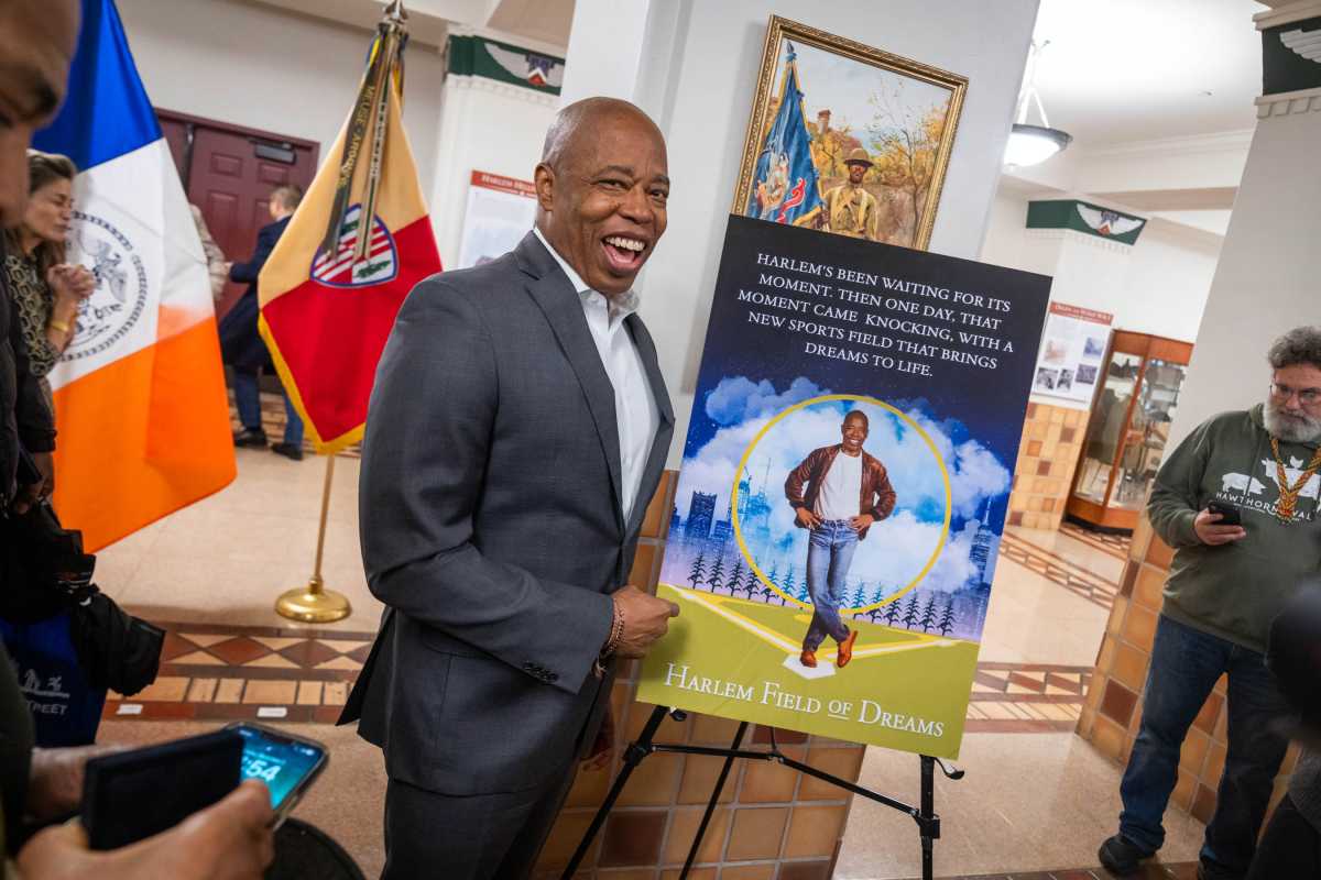 Clash of the Mayors: Mamdani to review Adams’ executive order barring Israel boycotts 2 Mayor Eric Adams smiling in front of poster bearing his image