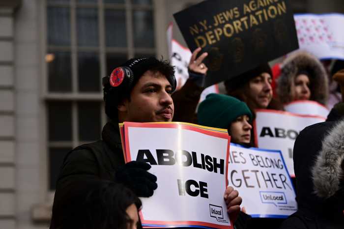 NYC Council members ramp up immigrant protections as ICE raids continue throughout the city 2 man holding a large sign and wearing a black coat