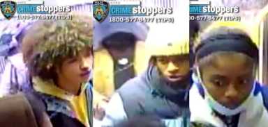 three people in winter clothes and one has a yellow hat