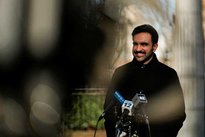 Mayor Zohran Mamdani smiling in front of camera