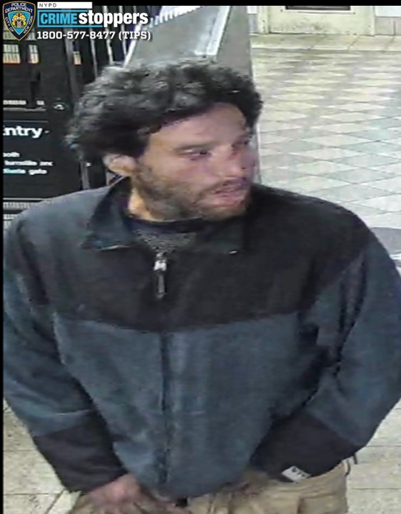 man wearing a dark jacket in a subway station