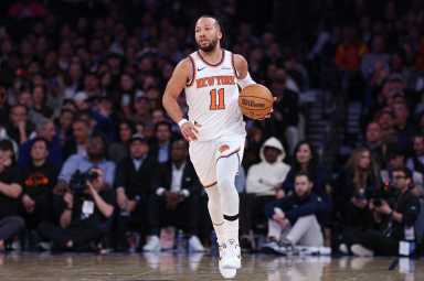 Jalen Brunson Knicks: Man in white uniform dribbles basketball up the floor