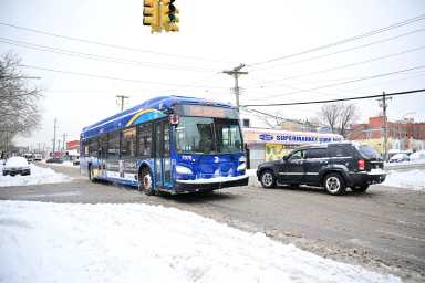 Bus driving on snowy street after winter storm