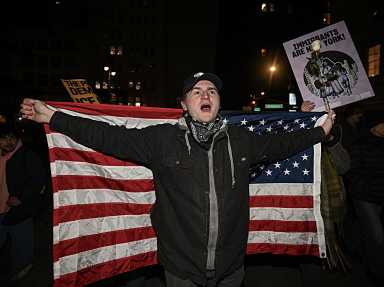 Man with American flag protesting in Foley Square after ICE shooting in Minneapolis