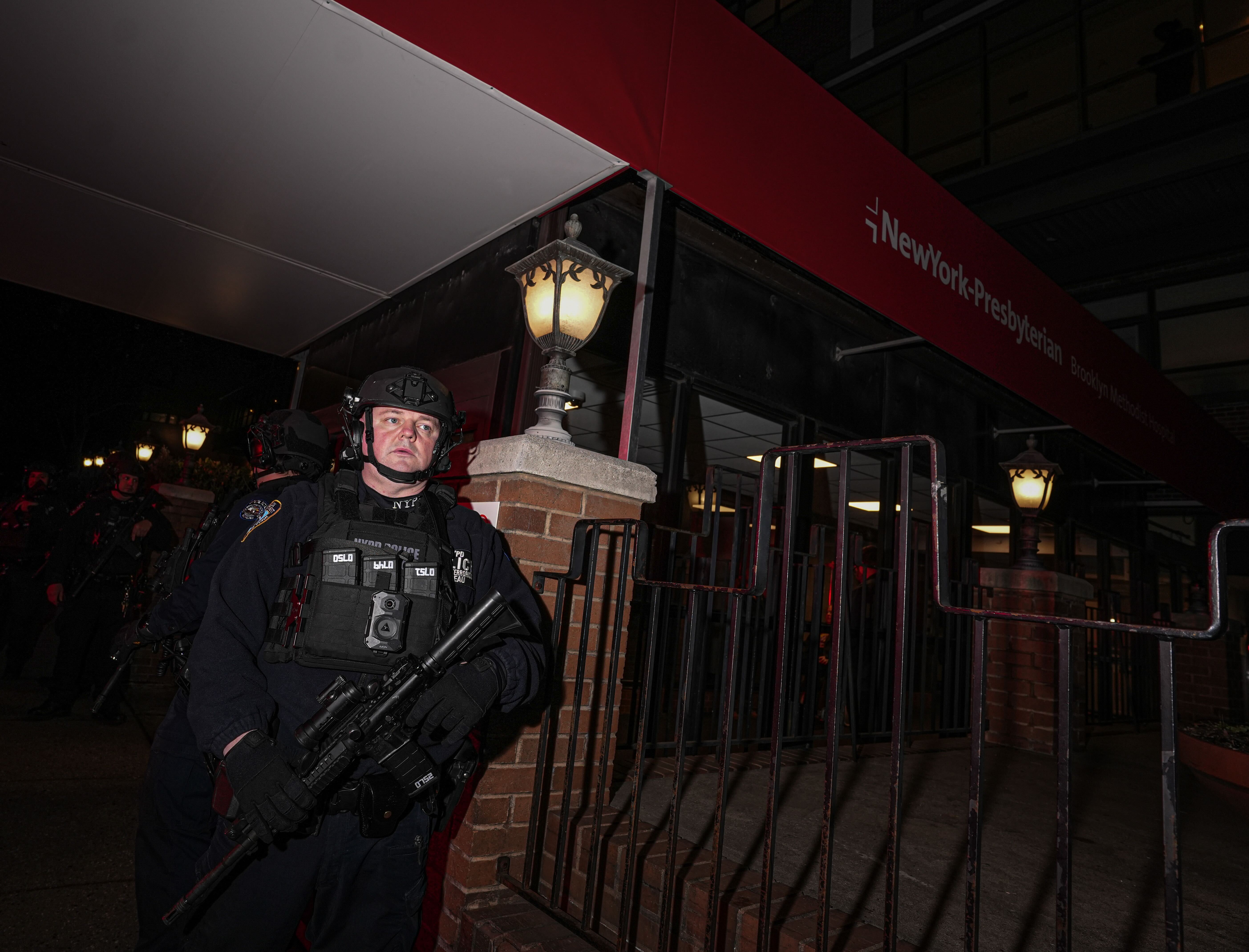 heavily armed officer outside Brooklyn hospital after police shooting