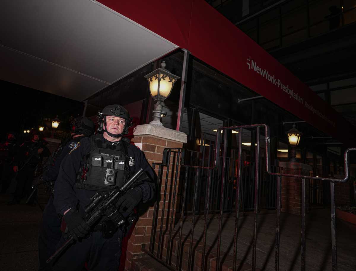 heavily armed officer outside Brooklyn hospital after police shooting