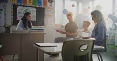 Mother and Father Looking at School Test Results of Their Son During Parents Evening. Teacher and Parents Happy About Excellent Academic Performance and Behavior of Elementary School Boy. Slow Motion.