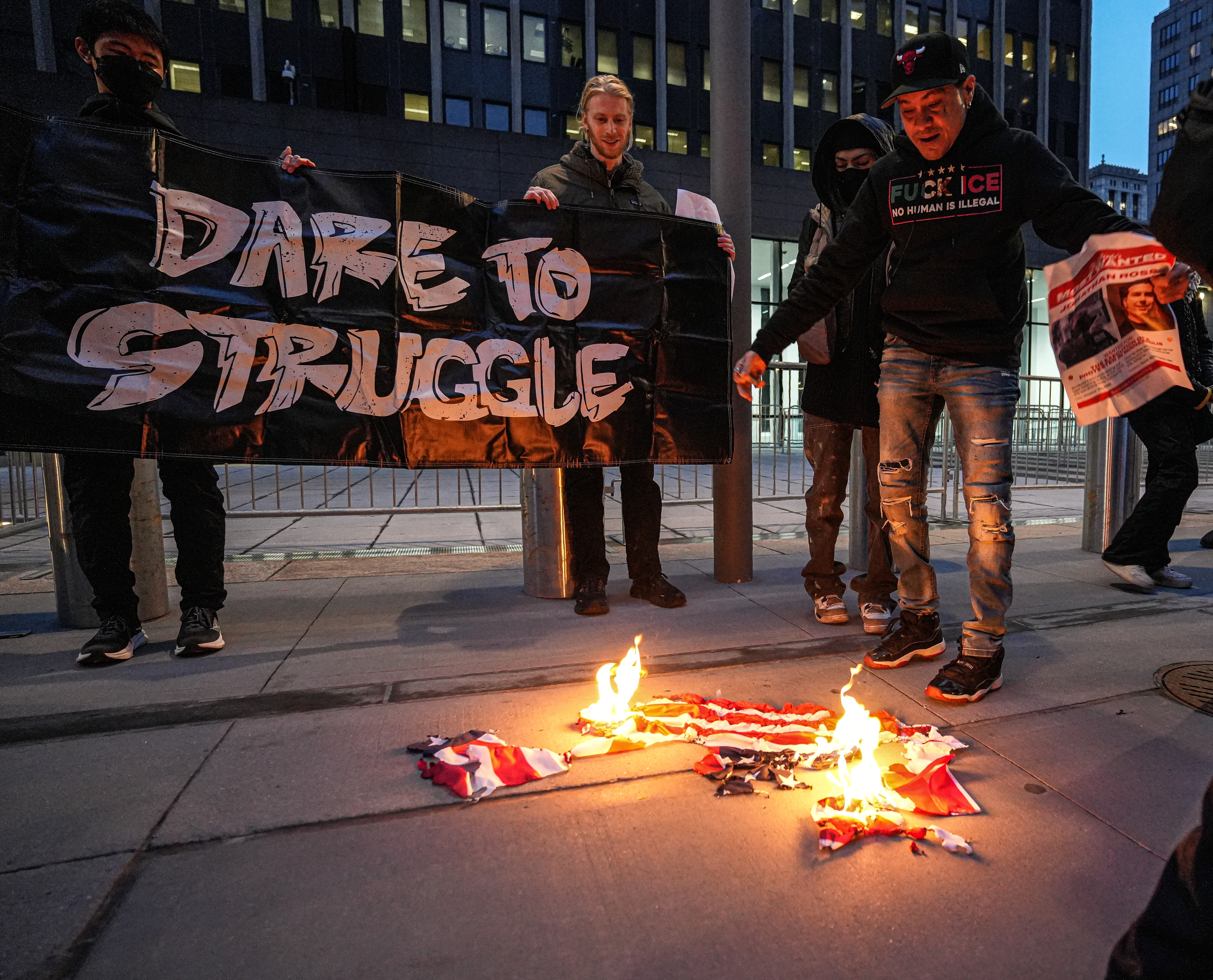 Anti-ICE protesters burn an American flag in protest