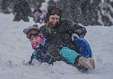 mom and child in nyc sledding