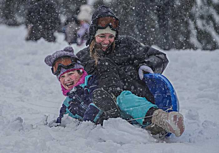 mom and child in nyc sledding