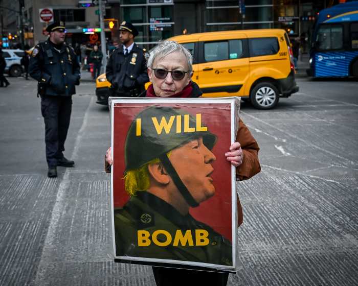 woman holding a protest sign in front of police officers