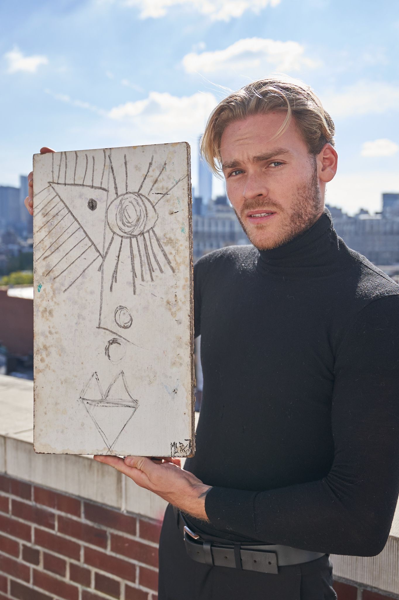 Artist Matthew Marcot on terrace in New York with one of his paintings
