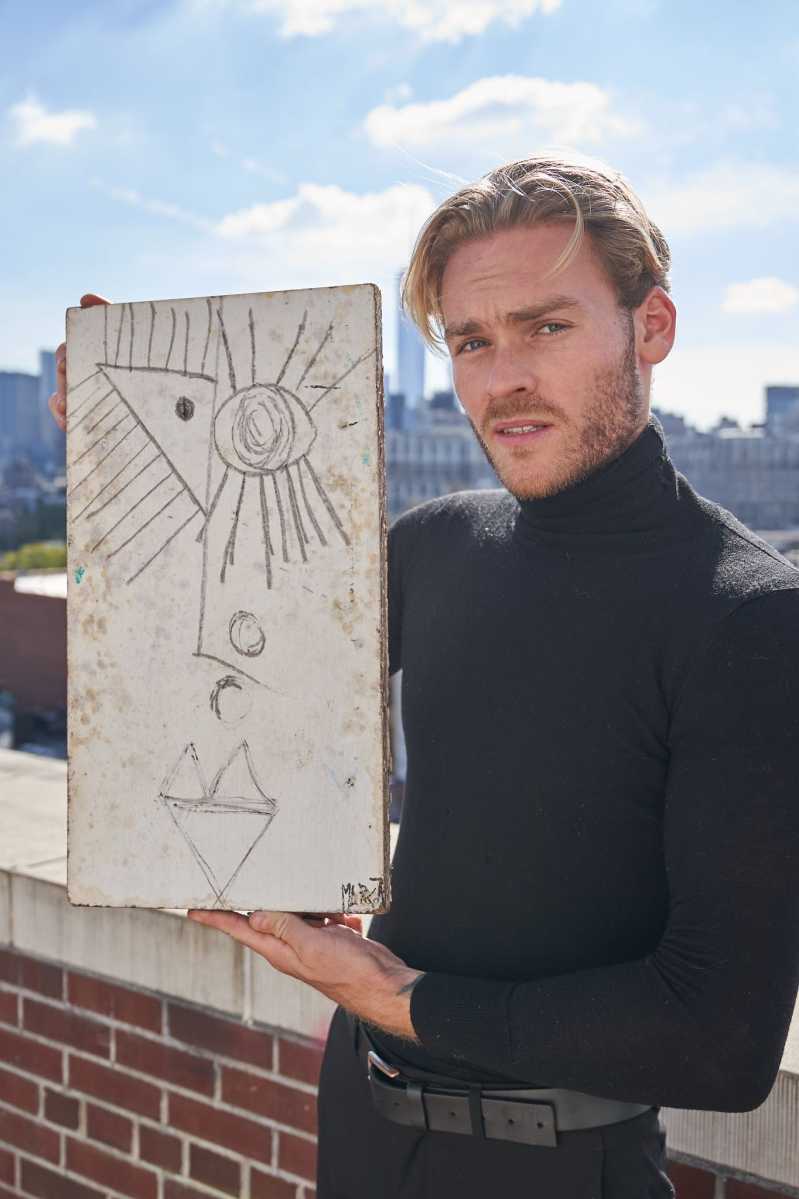 Artist Matthew Marcot on terrace in New York with one of his paintings