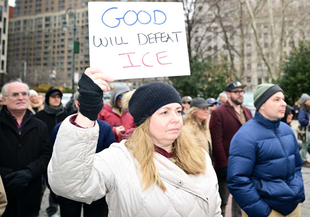 woman wearing a white coat holding a sign in NYC