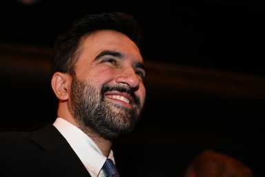 man smiling while wearing a suit